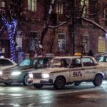 Nocna ulica w mieście z jadącymi taksówkami i światłami samochodów