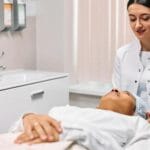 Kosmetolog wykonuje relaksujący zabieg pielęgnacyjny twarzy w gabinecie
