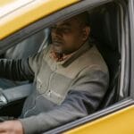Kierowca taxi czyta gazetę w zaparkowanym samochodzie podczas przerwy
