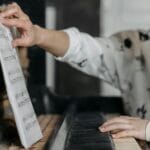 Dziewczynka ćwiczy grę na pianinie, patrząc na nuty