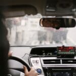 Kierowca taxi w lusterku wstecznym jadący ulicą miasta