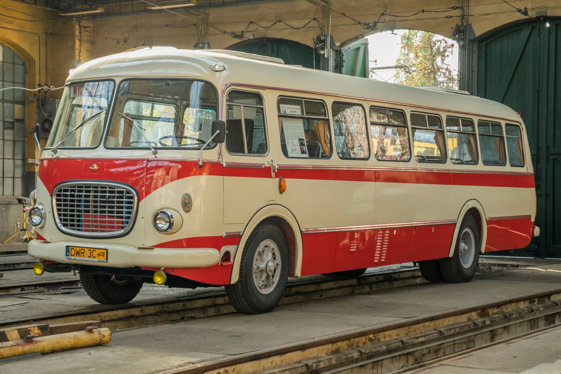 Klasyczny czerwono-biały autobus PRL w zajezdni tramwajowej we Wrocławiu
