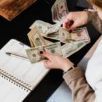 Kobieta przy biurku liczy gotówkę i planuje swoje finanse