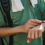 Mężczyzna w zielonej koszulce sprawdza kurs taksówki na smartwatchu