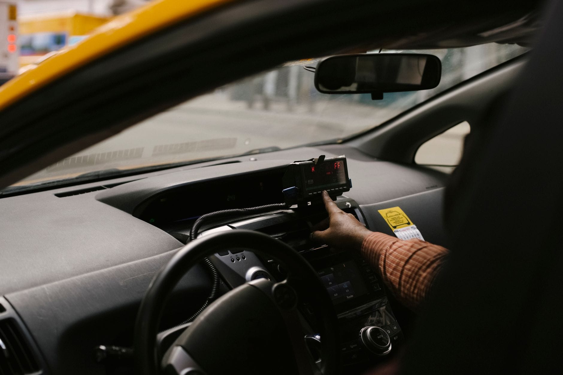 Jak prowadzić dziennik przejazdów w taxi żeby ułatwić rozliczenia podatkowe i kontrolę kosztów Kierowca taxi w mieście korzystający z nawigacji GPS podczas kursu
