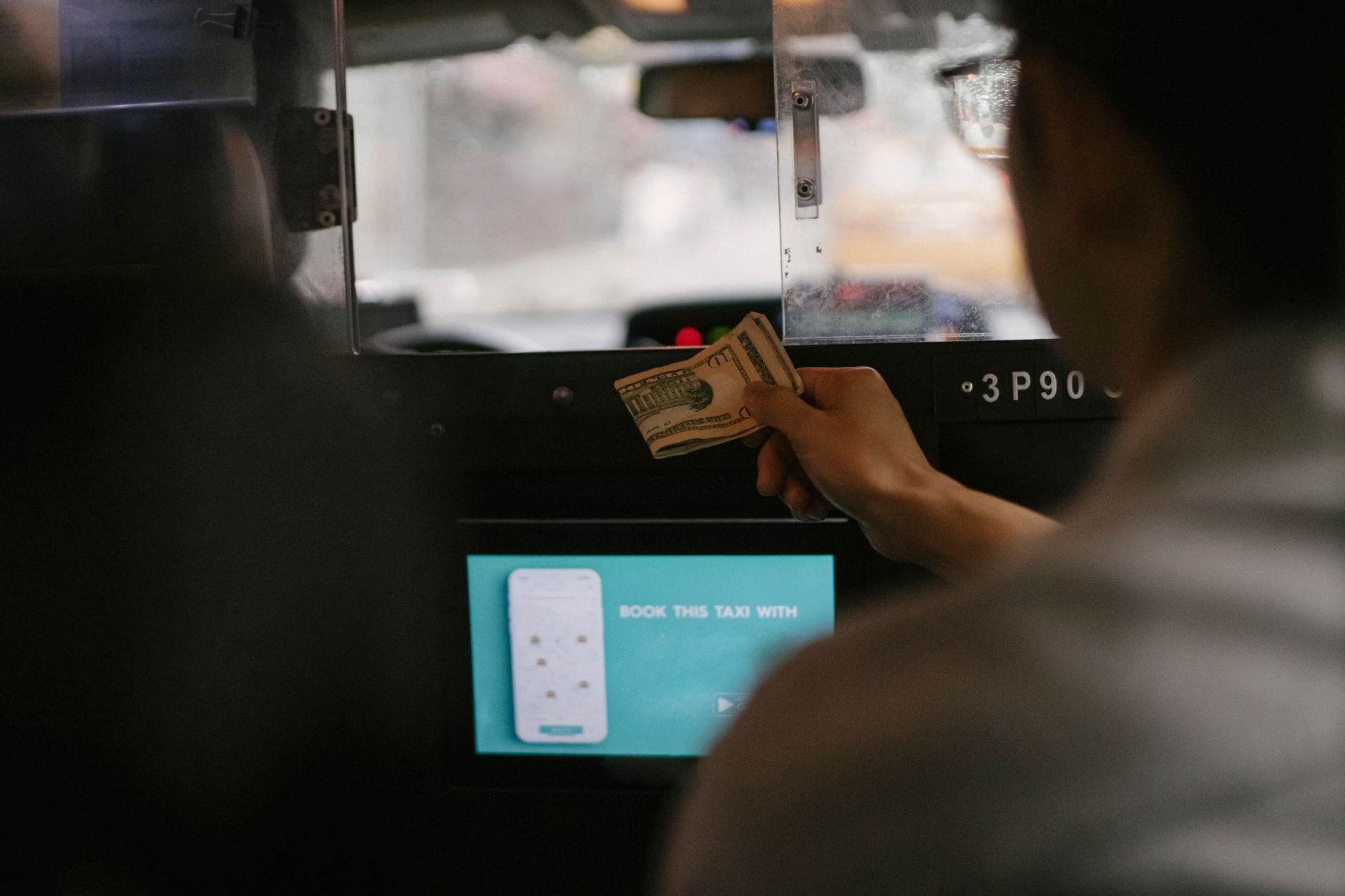 Kasa w smartfonie: jak działają płatności mobilne w taxi Pasażer płaci za kurs taksówki przy ekranie tabletu w oparciu fotela